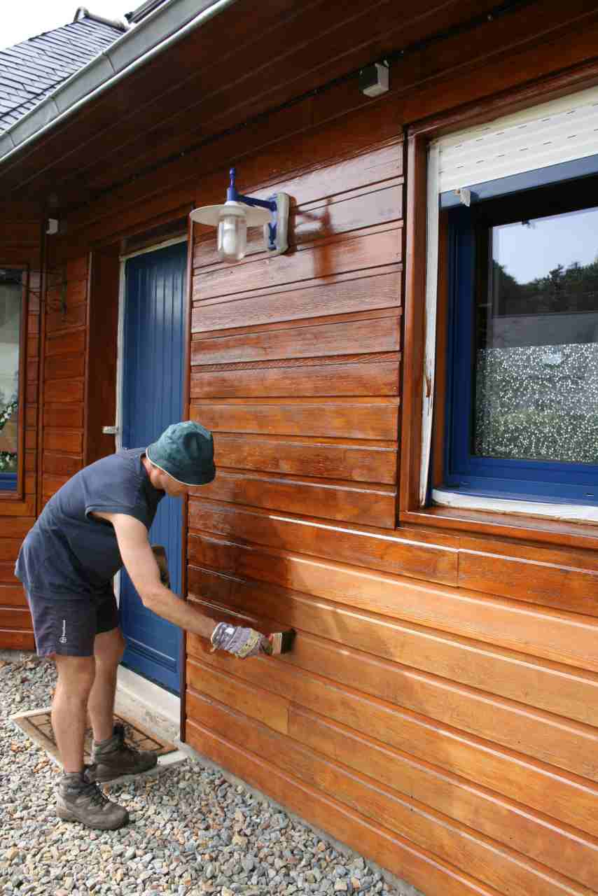Ein Mann trägt Linitop Classic mit einem Pinsel auf eine Hausfassade auf